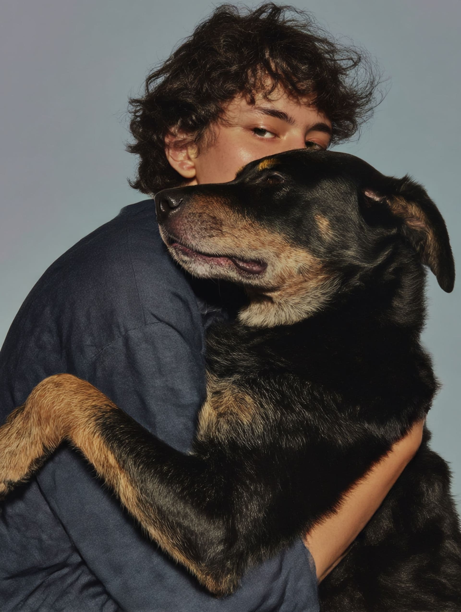 A person embracing their dog