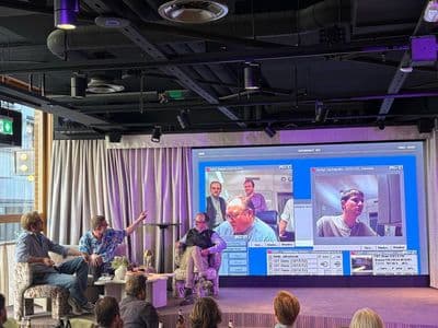 Johan Siwers and Christian Albinsson on stage at Angel House interviewing Serge Lachapelle, with a 1997 Marratech video-call screenshot on the big screen